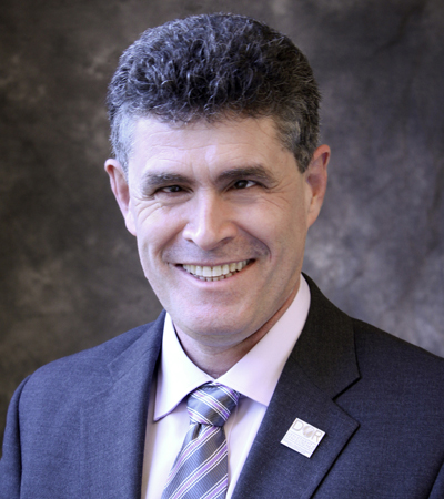 Man with dark hair wearing a suit and tie