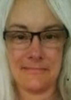 Woman with medium length white hair wearing prescription glasses